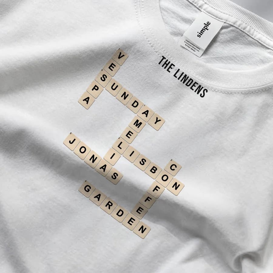 An interlocked crossword of family words printed as tiles on a white tee