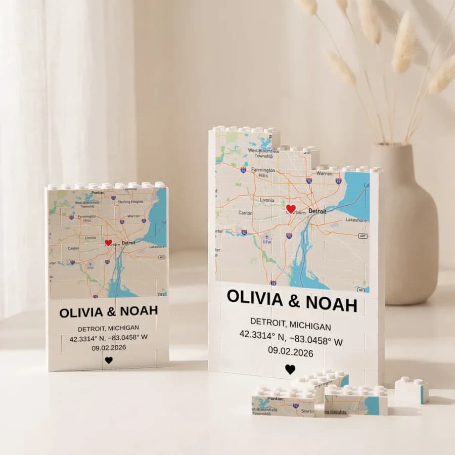 Two brick-built plaques of a Detroit street map with a heart on the location, the names Olivia and Noah and their coordinates below