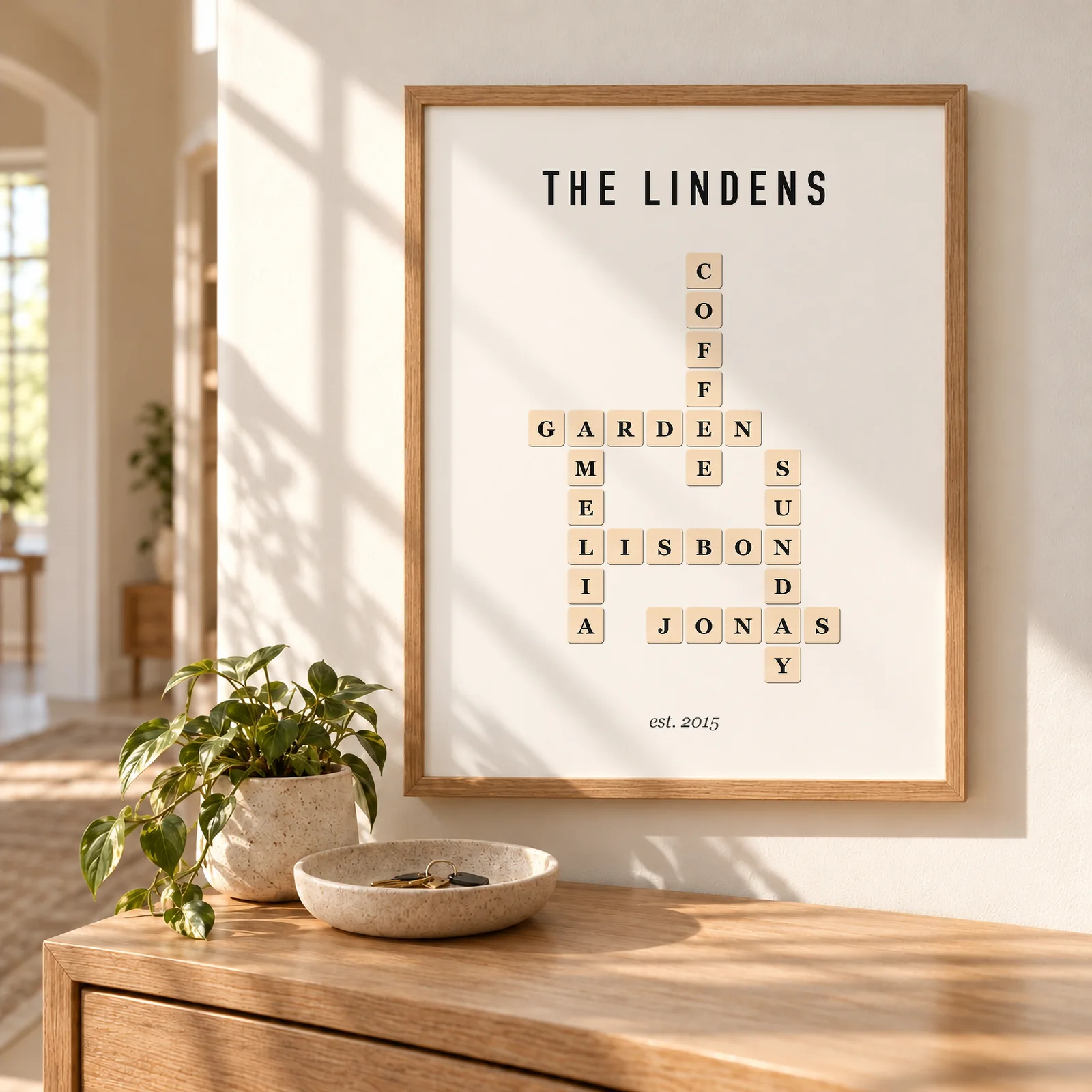 A framed crossword print in a sunny hallway: THE LINDENS over wooden letter tiles spelling GARDEN, AMELIA, COFFEE, LISBON, SUNDAY and JONAS, est. 2015